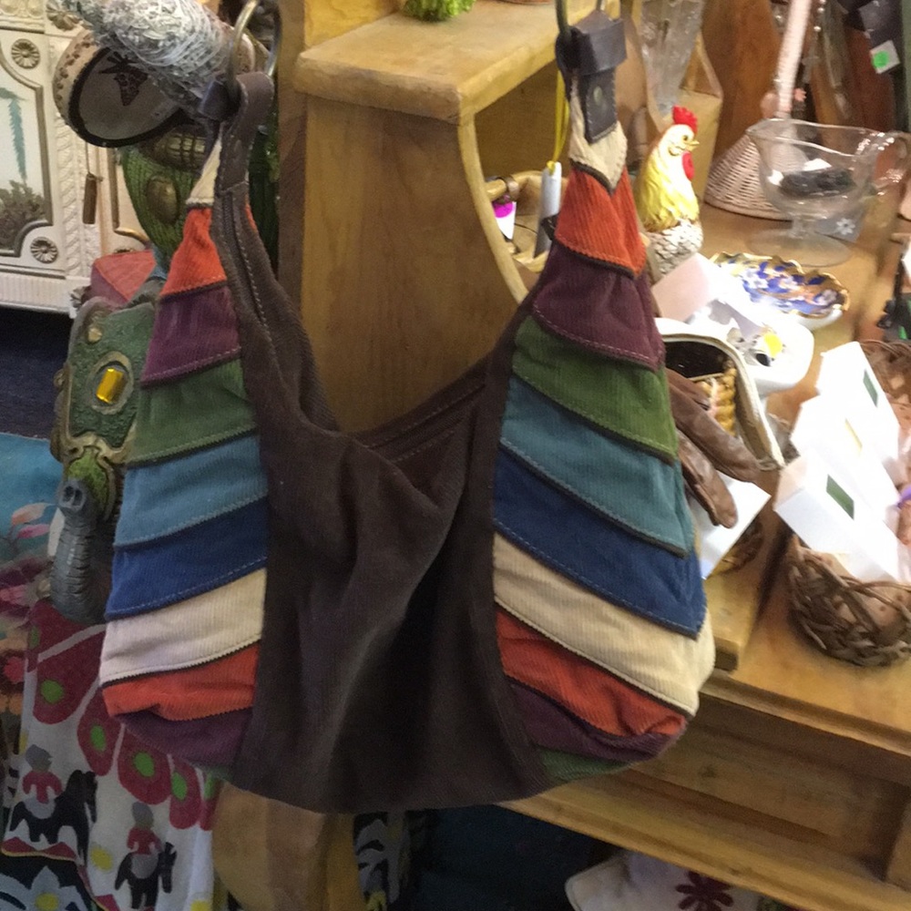 Corduroy bag with multi colored stripes on side.